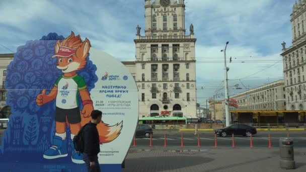 Banner oder Plakat mit lesik ist das Maskottchen der 2. Europaspiele 2019 in Minsk, Weißrussland 05.03.19. in der Nähe des "Tores von Minsk", einem architektonischen Komplex auf dem Bahnhofsvorplatz — Stockvideo