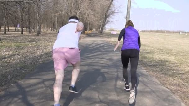 Kaukázusi Férfi és nő barátai vonat tavaszi Park, sportolás és fuss egy verseny, maratoni, lassú mozgás — Stock videók
