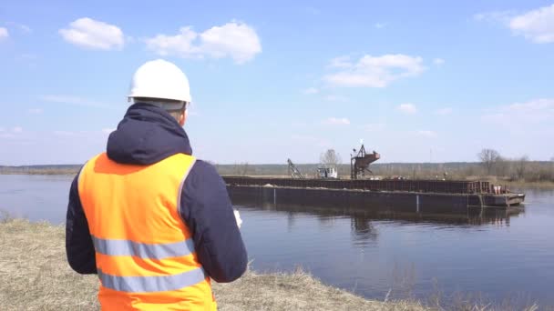 Inspecteur dans le gilet de signalisation surveille la qualité du travail d'extraction de sable fluvial pour la construction, l'industrie — Video