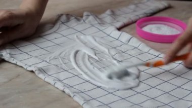 Kız leke çıkarıcı ile bebek giysileri üzerinde lekeleri temizler, yakın çekim, Kuru Temizleme