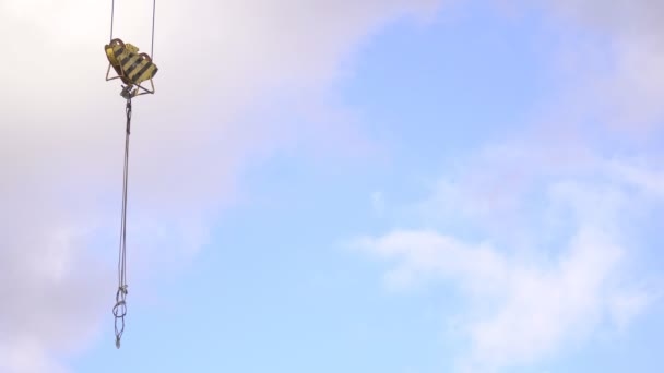 Big hook of a tower crane against the blue sky with clouds concept of business in the construction of buildings and structures, copy space, lifting hook — Stock Video