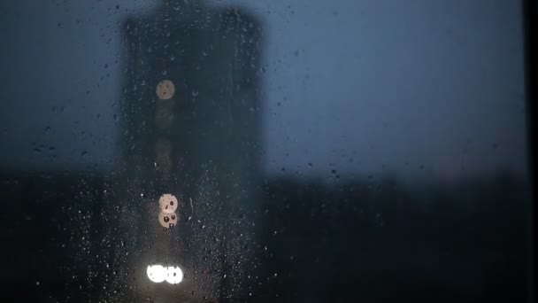 Chuva forte com relâmpagos e vento, um furacão fora da janela. Tempo noturno na cidade. Gotas de chuva fluem para baixo do vidro, lapso de tempo, espaço de cópia — Vídeo de Stock