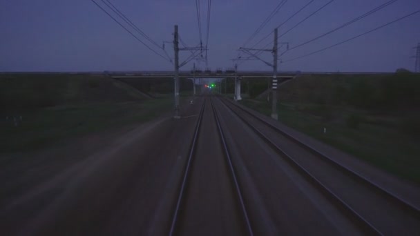 Chemin de fer en soirée, vue de la voie ferrée depuis la fenêtre du dernier wagon, feux et gare, arrière-plan, espace pour copier, extérieur — Video