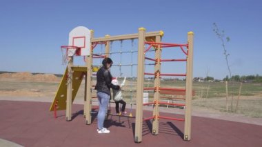 Küçük güzel beyaz kız 3 yaşında çocuklar için modern bir oyun alanında annesi ile oynar, spor ekipmanları