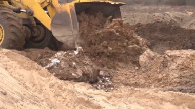 Sarı büyük inşaat yükleyici seviyeleri inşaat için arazi bir parça ve bir kova, sanayi, güç arazi toplar