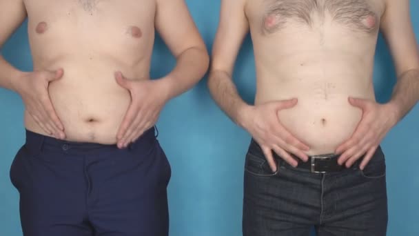 Two men with fat fat bellies touch wrinkles on the belly, irregular lifestyle, health, slow motion, excess weight — Stock Video