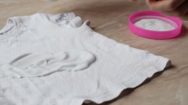 Anne leke çıkarıcı ve çamaşır tozu yardımı ile şekerlerden çocuk giysileri üzerinde lekeleri temizlemek için, yakın çekim, leke giderme, ev işi
