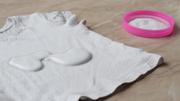 Madre para limpiar las manchas en la ropa de los niños de caramelos con la ayuda de removedor de manchas y polvo de lavado, primer plano, eliminación de manchas, higiene — Vídeos de Stock