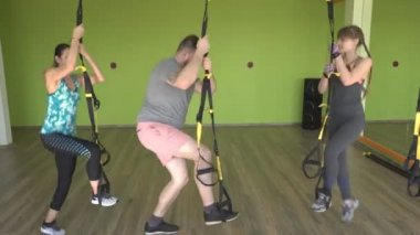Bir adam ve bir kız Trx döngüleri üzerinde egzersizleri Bulgar split-squat, kalça, bacak ve kuadriseps, baget kasları güçlendirilmesi performans meşgul