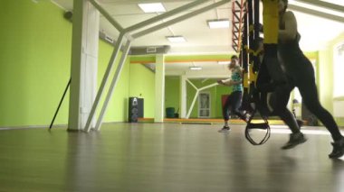 Grup sınıfları kız ve erkek bir eğitmen ile Trx döngüler, kilo kaybı ve dayanıklılık, kuvvet eğitimi gelişimi meşgul