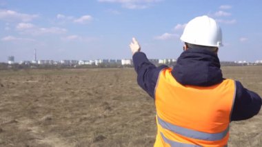 Bir erkek mühendis yeni bir binanın şantiyede telefonda konuşuyor ve temel, sanayi, kopyalama alanı döşeme