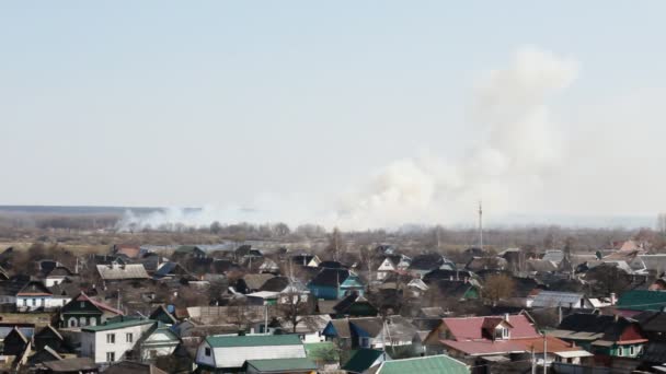 Fuerte casa de la quema de hierba seca en primavera contra el cielo, espacio de copia, paisaje — Vídeo de stock