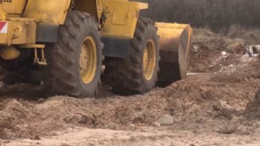 Sarı büyük inşaat yükleyici seviyeleri inşaat için arazi bir parça ve bir kova, sanayi, inşaat ekipmanları arazi toplar