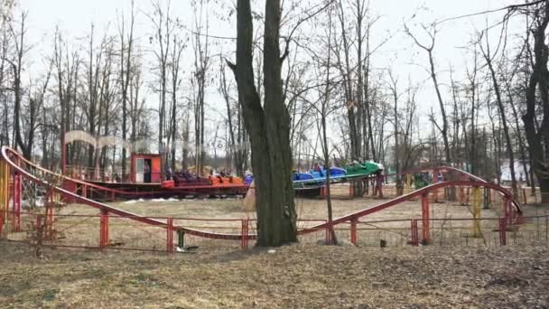 Stará maličká rollerastr v zábavním parku. Lidé v kabin jedou v kruhu. Děti se baví a Radou. — Stock video