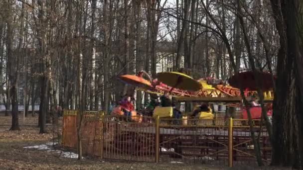 Ludzie jeżdżą na przejażdżkę tęczy w parku rozrywki wiosną w Bobruisk, Białoruś 03.09.19. Szczęśliwych ludzi spin na kolorową atrakcją w parku rozrywki na otwartym powietrzu. — Wideo stockowe