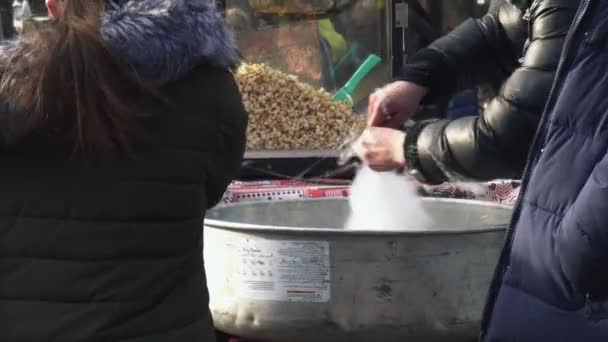 Cotone zucchero filtra attraverso foro minuto. La gente compra filo interdentale fata bianca al luna park — Video Stock