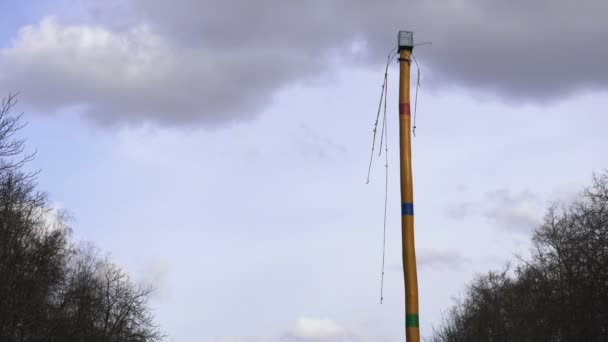 A wooden Maslenitsa pole stands with an empty cage and ropes hanging down in the park during the Eastern Slavic religious and folk holiday of Butter Lady. — Stock Video