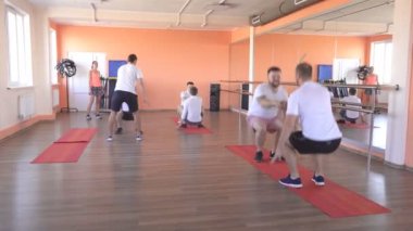 Beyaz çocuklarla modern bir fitness merkezinde eşleştirilmiş sınıflar, spor salonunda Grup sporları kasları güçlendirmek ve kilo vermek, dostluk