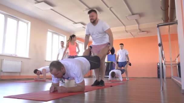 Parade klasser i ett modernt gym med kaukasiska killar, grupp sporter i gymmet för att stärka musklerna och gå ner i vikt, vänskap — Stockvideo