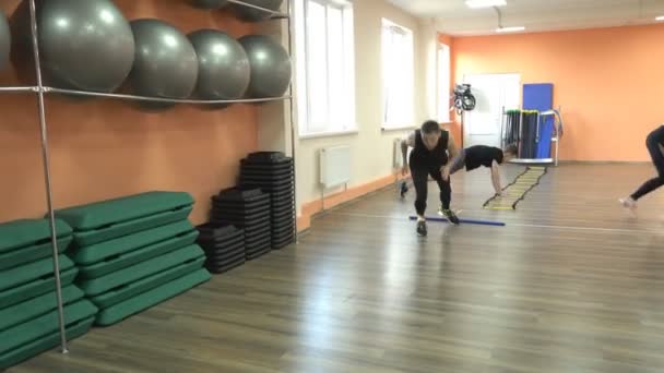 BOBRUISK, BELARUS - 4 de abril de 2019: Hombres y niñas participan en un moderno gimnasio, una lección de grupo sobre el método de tabata, realizar cargas cardiovasculares — Vídeo de stock