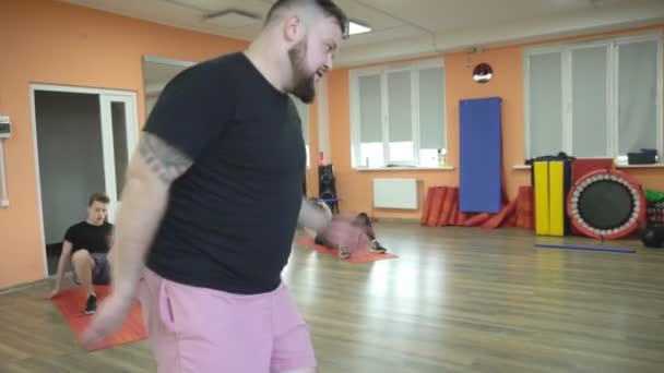БОБРУЙСК, БЕЛАРУС - 4 апреля 2019 года: Мужчины и девочки занимаются в современном фитнес-центре, групповом классе по методике табата, замедленной съемки — стоковое видео