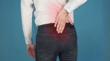 Omurga veya omurga olarak da bilinen vertebral kolonda ağrı, bilgisayarda uzun süreli çalışma nedeniyle radikülit kavramı. Beyaz gömlekli bir adam bel omurlarında veya sakrumda ağrı çeker.