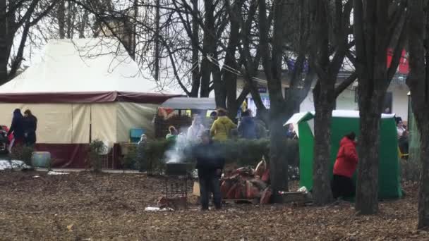 벨라루스 보브루스크에서 열리는 축제 기간 동안 놀이 공원의 망갈에서 바비큐 샤슬릭을 구운 사람 03.09.19. 한 남자가 축제 기간 동안 유원지에서 그릴에서 고기를 요리합니다.. — 비디오