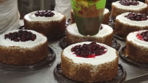 Making and decorating pastry cakes with fresh cherries. Decorating cream with a confectionery syringe. Food industry. — Stock Video