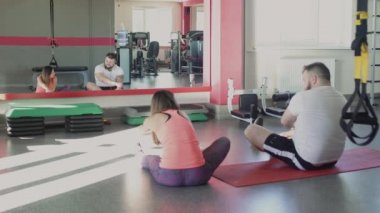 Fitness merkezinde eğitim den sonra erkek ve kişisel antrenör dinlendirici. Özel ince antrenör ile Kalın obez adam spor salonunda fiziksel jerks ve egzersizleri yapmak. Kilolu kişi ve kadın kalori yakmak