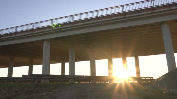 Il moderno camion carro trasporta merci sullo sfondo di un tramonto e un ponte, il concetto di logistica e trasporto merci — Video Stock