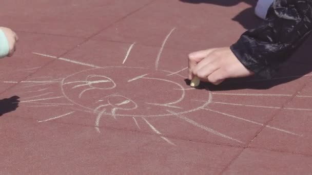 Bela mãe branca desenha com lápis de cor com sua filhinha de 3 anos no playground, verão — Vídeo de Stock