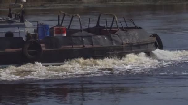 Ein alter Lastkahn mit einem Schlepper, der den Fluss entlang segelt, kopiert Raum, Transport, Flussboot, Wassertransport, Industrie — Stockvideo