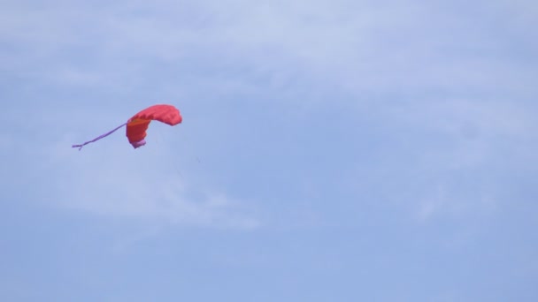 Moscas aéreas multicolor cometa en el cielo azul, fuerte viento, fondo, espacio de copia — Vídeos de Stock