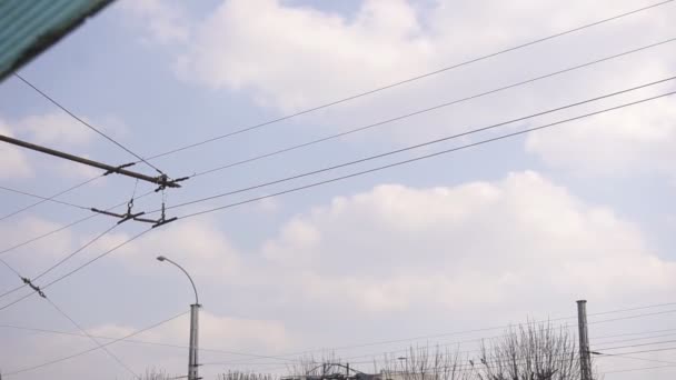 Электрические провода, по которым идет троллейбус в городе, фон — стоковое видео