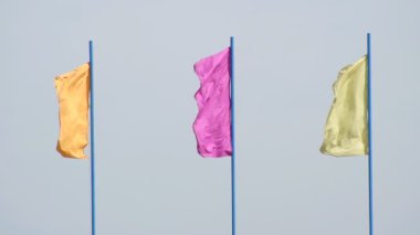 Çok renkli şenlikbayrakları mavi bir gökyüzü, arka plan, şenlikli, yavaş hareket, sembolik karşı rüzgarda gelişmeye