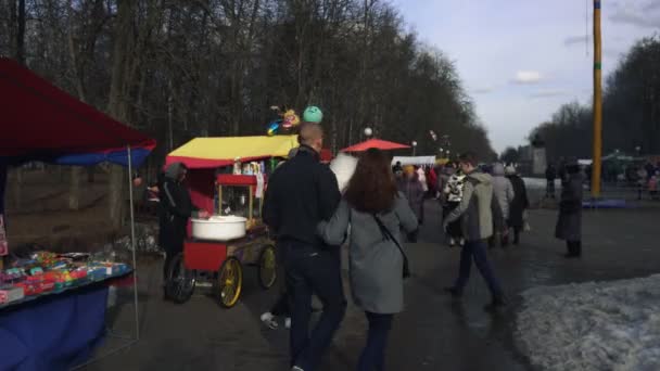 Oamenii merg în parc în timpul sărbătorii religioase slave răsăritene Maslenitsa în BOBRUISK, BELARUS 03.09.19 primăvara. Cetățenii petrec timp în parcul orașului în timpul sărbătorii primăverii . — Videoclip de stoc