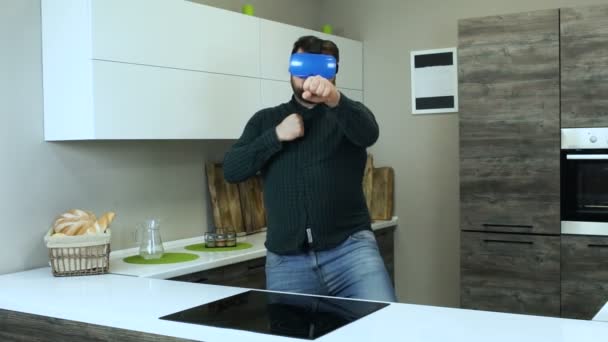 Engraçado cara grosso em capacete-montado exibe joga no mundo virtual em simulação de cozinha. O jogador masculino com fone de ouvido VR como um cozinheiro . — Vídeo de Stock