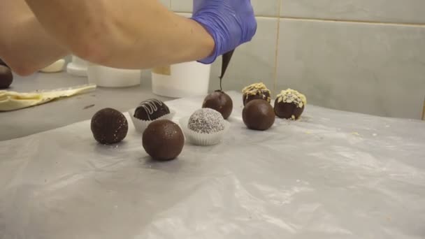 Dekoration und Herstellung von runden Schokoladenkuchen. Frauen backen Kuchen in einer Süßwarenfabrik. Sahne-Deko-Bonbons, Kakao — Stockvideo