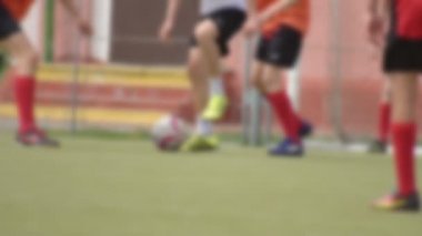 Kafkas çocuklar yeşil bir alanda futbol oynamak, adam bir feint yapar, arka plan, yavaş hareket, bulanık