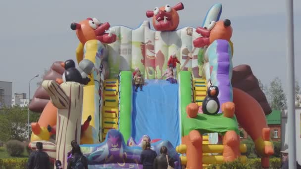 Large multi-colored inflatable trampoline on which children jump, celebration and fun, attraction, BELARUS, Bobruisk - May 1, 2019 — Stock Video