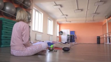 Kafkas kadın eğitmen yoga dersleri, shavasana duruş, erkek arkadaşlar yalan ve dinlenmek, restorasyon ve tüm organizmanın yenilenmesi, hafiflik ve barış hissi, fitness merkezi yapar