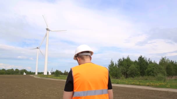 Mužský inženýr provádí inspekci a inspekci větrné turbíny, která vyrábí elektřinu otáčením nožů větrem, větrnou generátorem a průmyslem. — Stock video