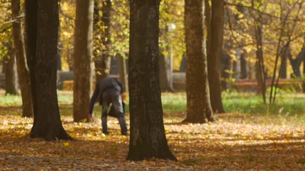 Un anciano o jubilado con barba gris y con una bolsa pasea en el parque de otoño en BOBRUISK, BELARUS 10.16.18 — Vídeo de stock