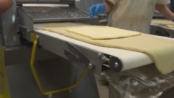 Una cocinera pone un pedazo grande de mantequilla en una hojaldre para hacer pastel en la producción, productos de panadería — Vídeo de stock