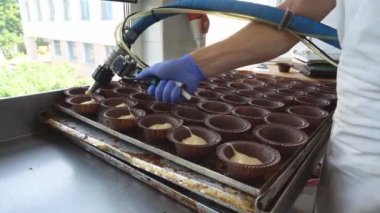 Pişmiş ürünler Muffins manuel imalatı. Fırında pişirme için bir cupcakes hızlı ekmek hazırlanması. Hamur bireysel kağıt kalıpları veya formları içine dökülür. Un şekerleme üretimi