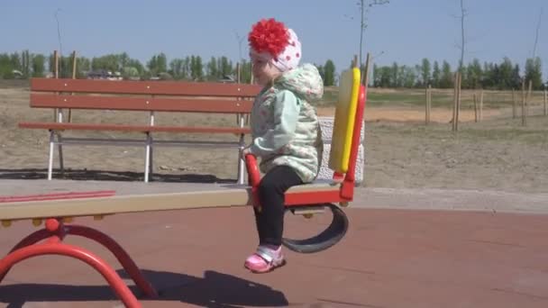 Little beautiful caucasian girl 3 years old plays with her mother in a modern playground for children, balance — Stock Video