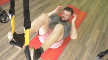 Şişman kafkas sakallı adam Trx döngüleri modern fitness merkezinde çalışıyor, dayanıklılık ve kas geliştirme, aşırı kilo