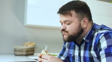 Aşırı kilolu bir adam hamburgerini yiyor ve alkolsüz içecek soda içiyor. Adam ev yapımı yemeklerden hoşlanır. Sağlıksız Lifestyle, kızarmış ve zararlı yüksek kalori Gıda. Obezite ve kilolu riski.