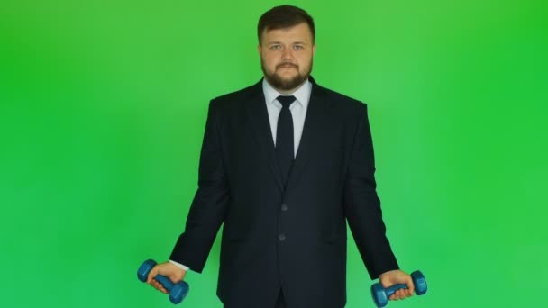 İşadamı ve sağlık kavramı. Takım elbiseli adam chromakey yeşil üzerinde Dambıl ile egzersizleri yapıyor. Ceket, gömlek, kravat ve pantolon tombul sakallı kişi spor spor salonunda egzersiz yapar. Yeşil — Stok video