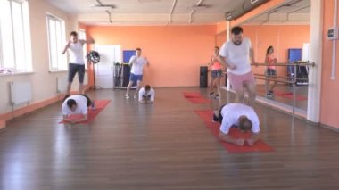 modern bir fitness merkezinde grup çiftler kafkasyalı erkekler kilo vermek ve sağlık, grup eğitimi teşvik etmek için atlama egzersizleri yapmak